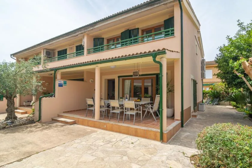 A two-story house with a covered patio and outdoor dining area.
