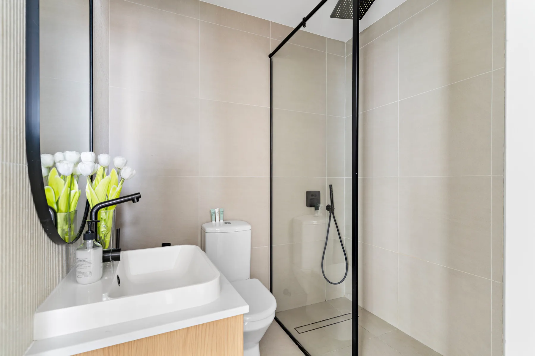 Un baño moderno con lavabo y ducha con paneles de vidrio.