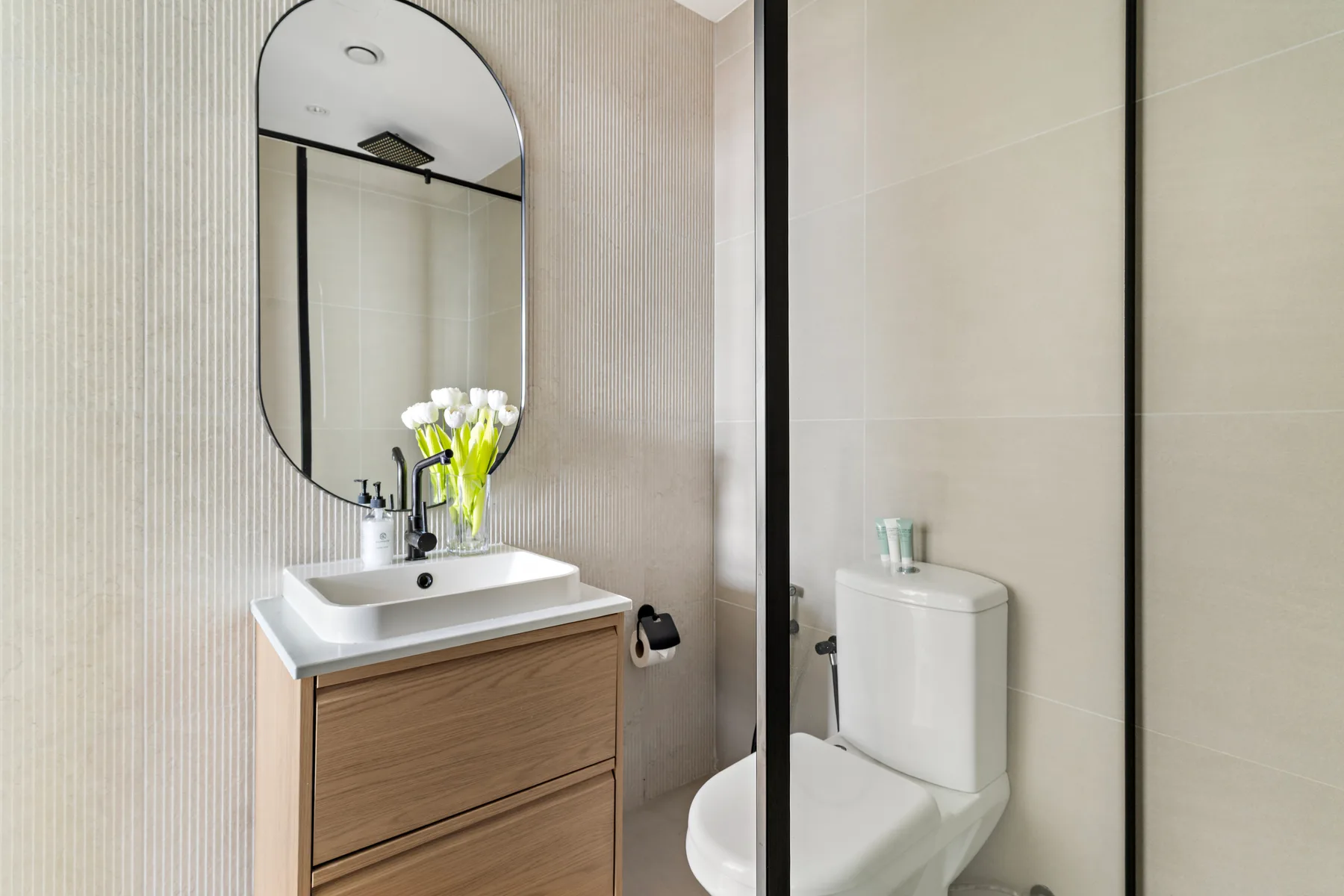 Un baño moderno con un mueble de madera, lavabo e inodoro.