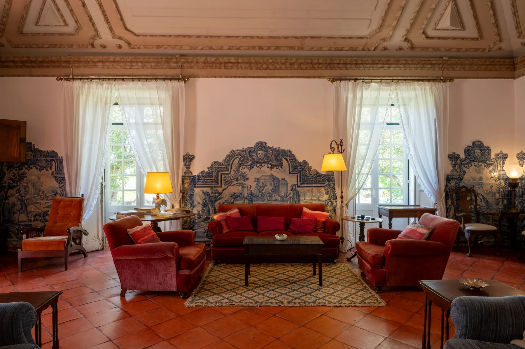 Una sala de estar con asientos rojos alrededor de una mesa de centro.