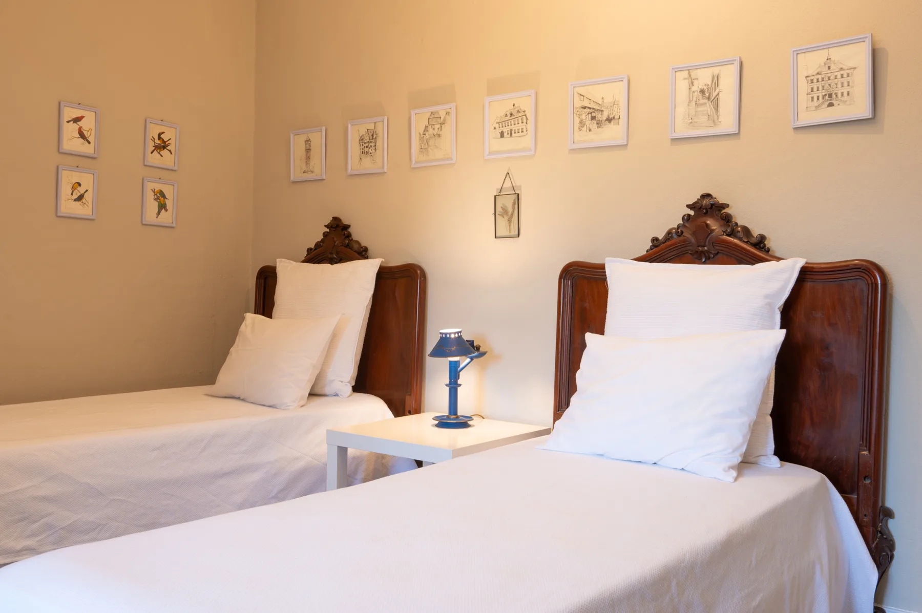 Un dormitorio con dos camas y cuadros en las paredes.