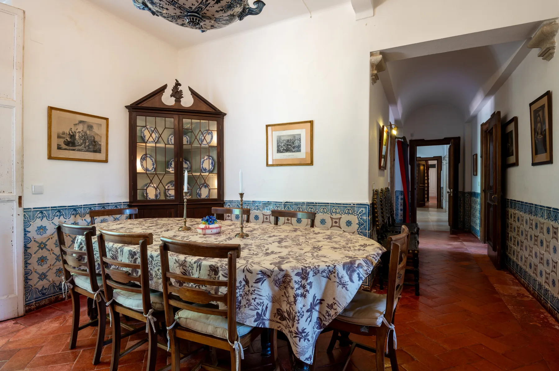 Un comedor con una mesa larga, sillas y una vitrina.