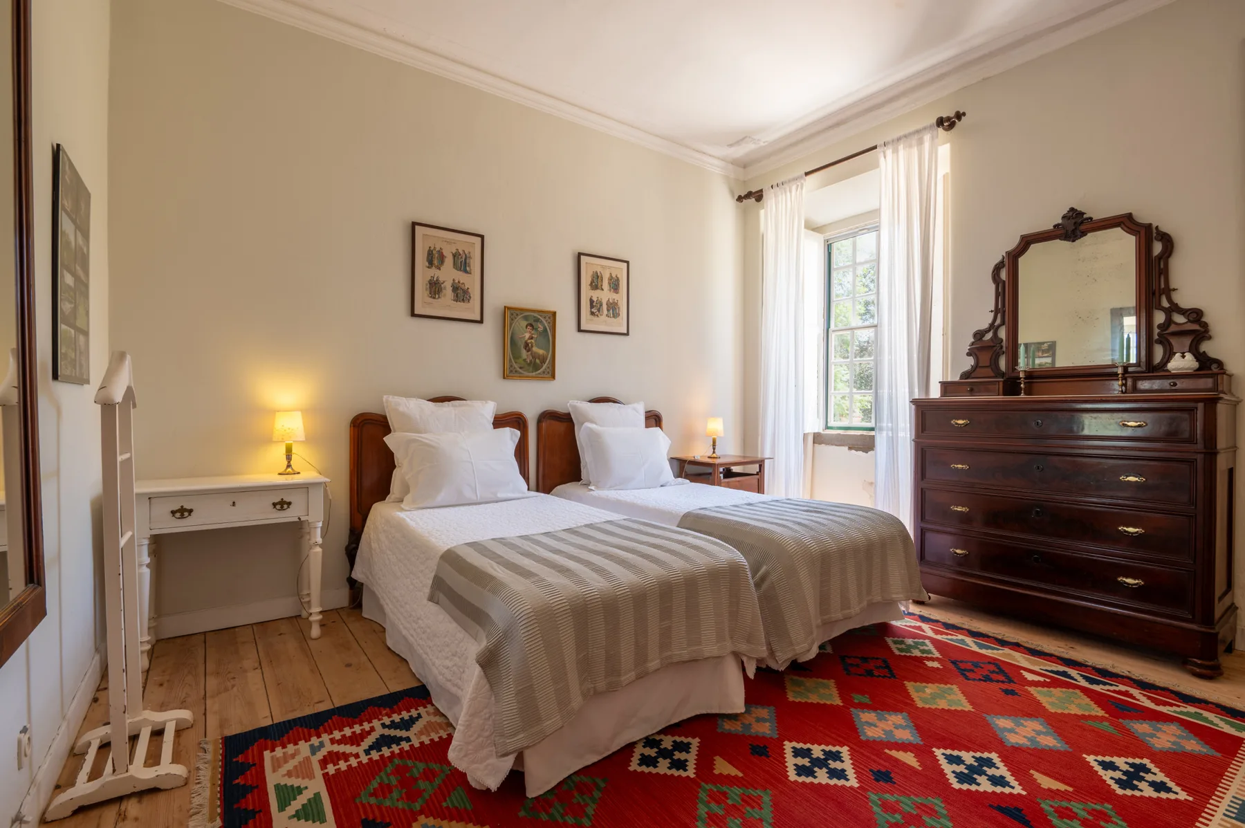Un dormitorio con dos camas, mesillas de noche y una cómoda de madera grande.