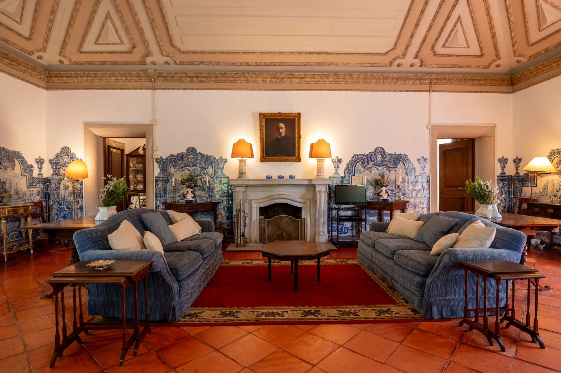 A formal living room with seating arranged around a fireplace.