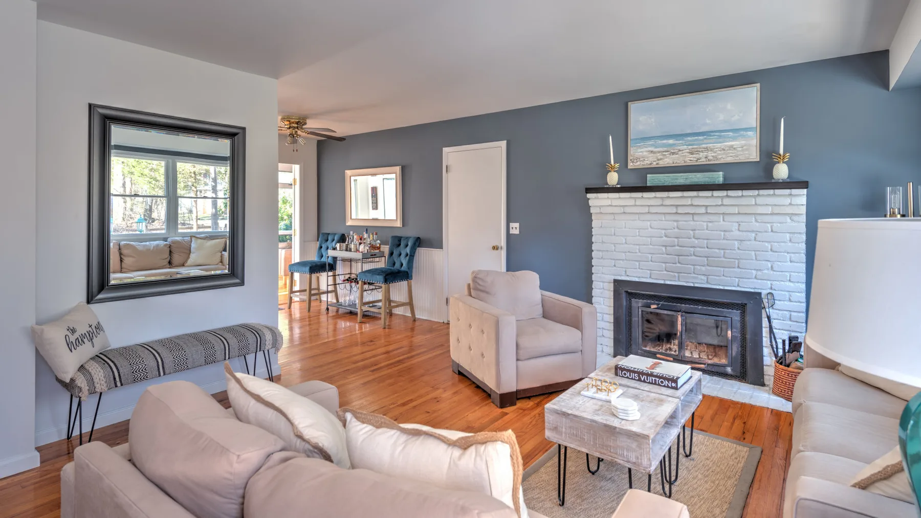 A living room with seating arranged around a fireplace and coffee table.