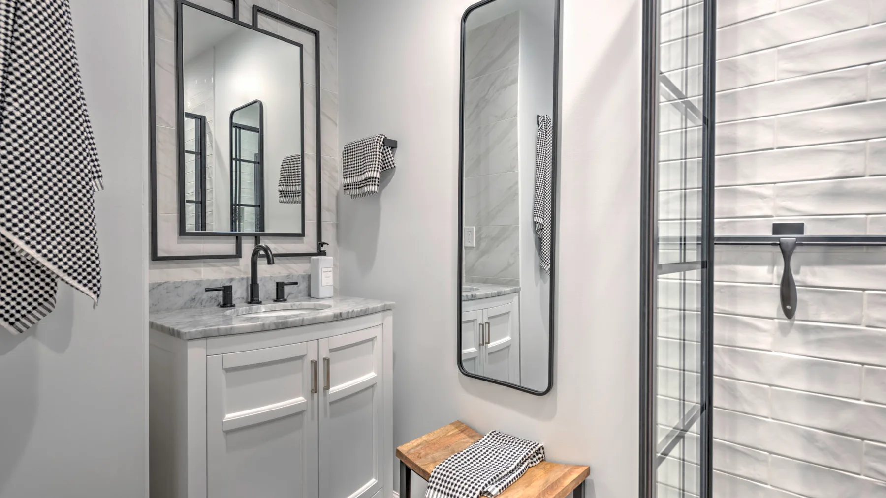 A bathroom vanity with a sink and a glass-enclosed shower.