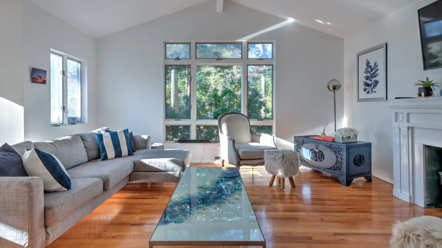 A bright living room with seating arranged around a glass coffee table.
