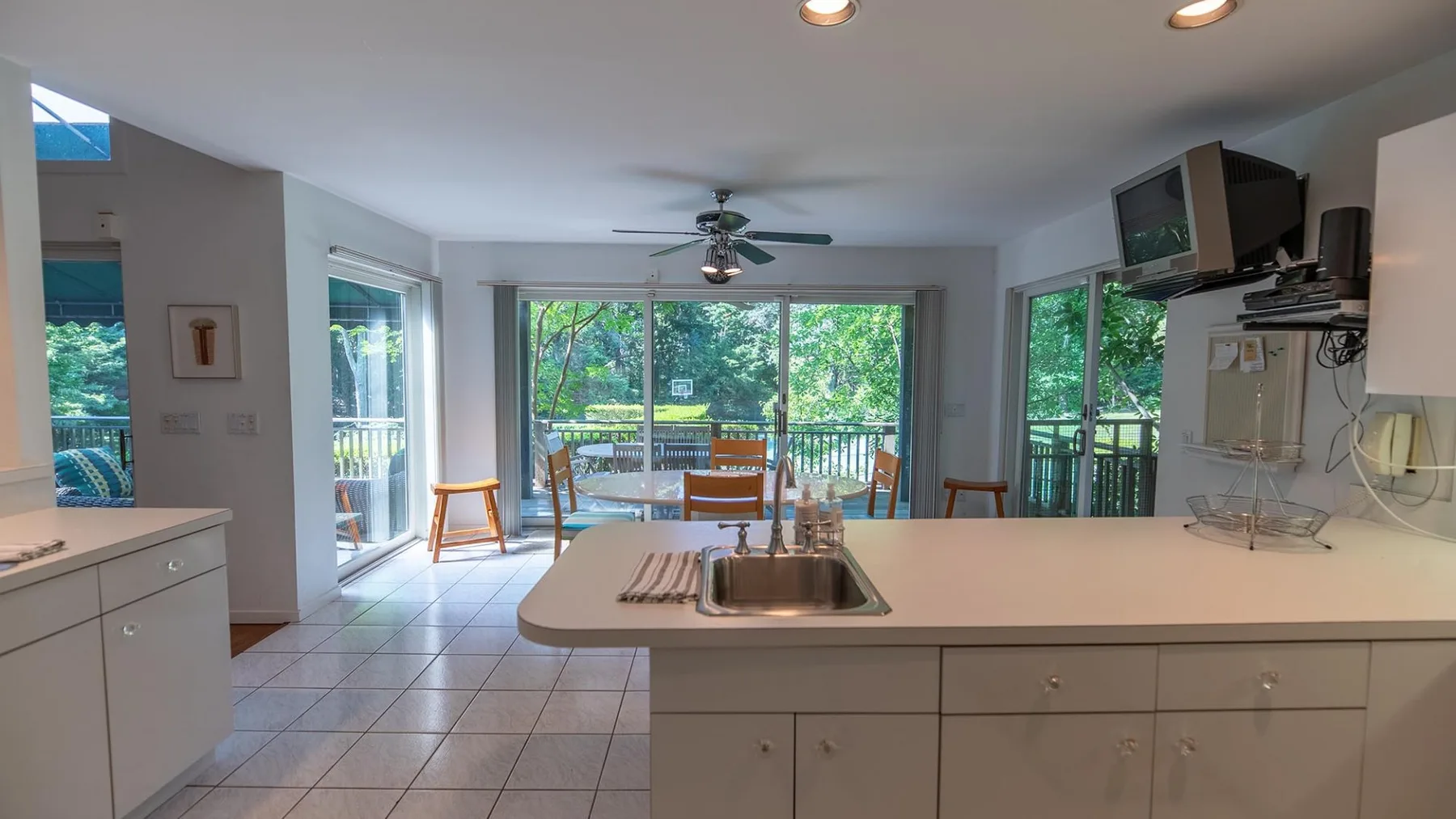 Una cocina luminosa con una isla y grandes ventanas con vista a la vegetación.