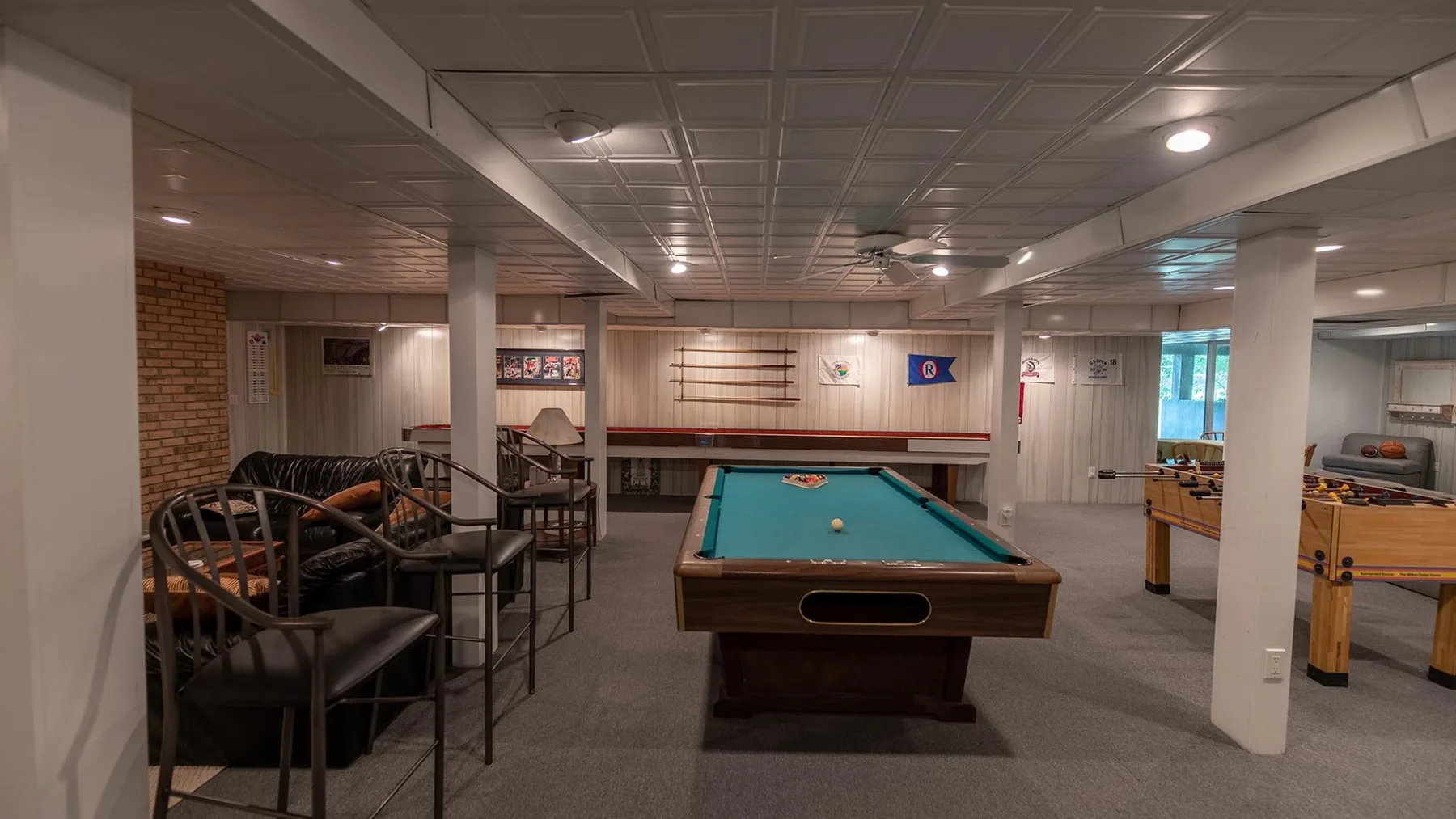 Una sala de recreación con una mesa de billar y asientos.
