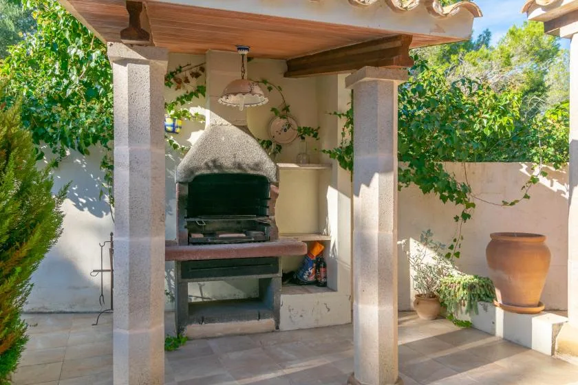 A covered outdoor cooking area features a built-in oven and countertop.