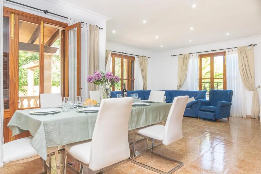 A bright living and dining room with a dining table and blue seating.