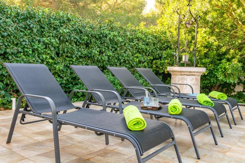 Outdoor lounge area with reclining seating and bright green towels.