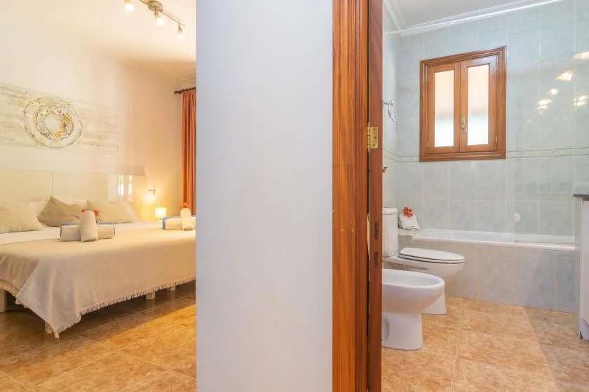 A bedroom and bathroom are visible through an open doorway.