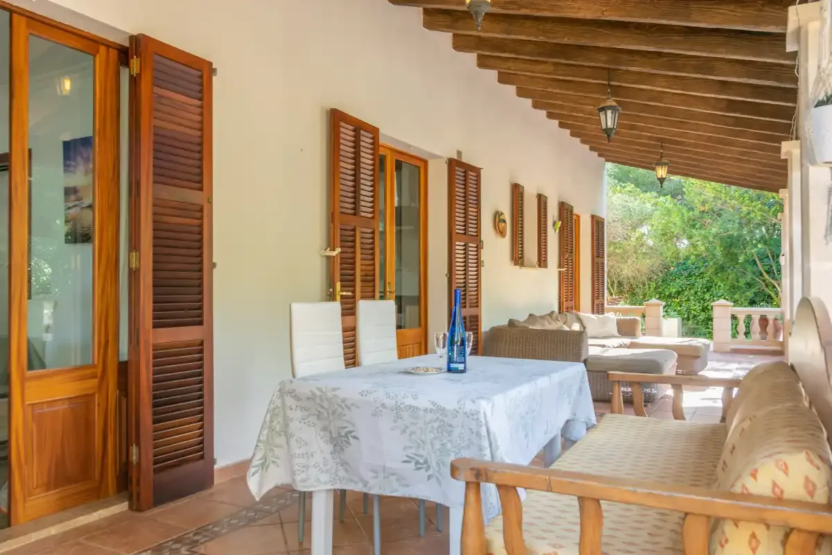 A covered outdoor dining area with a table and seating.
