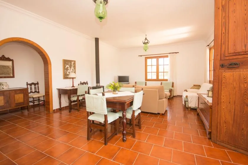 Un luminoso salón-comedor con una mesa de madera y asientos.