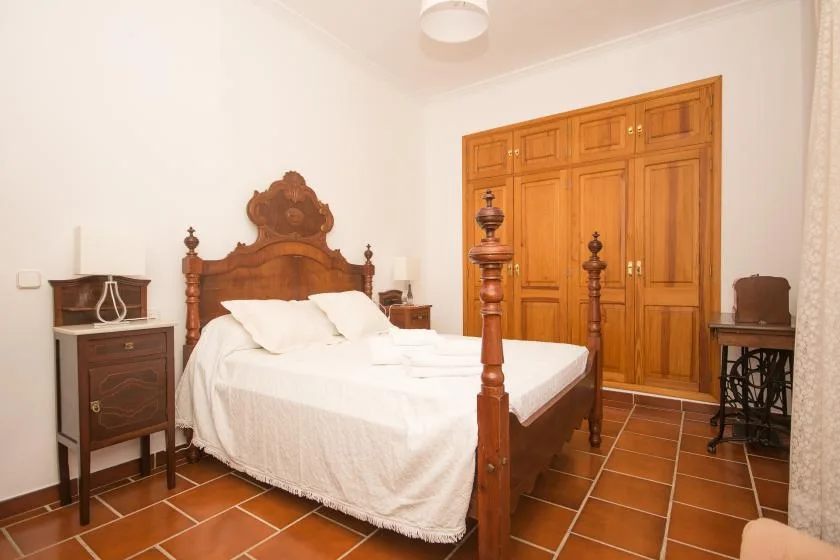 Un dormitorio con una cama de madera y un armario a juego.