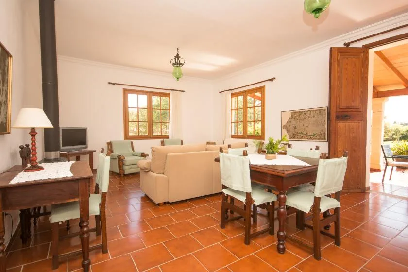 Un luminoso salón-comedor con asientos, una mesa y ventanas.