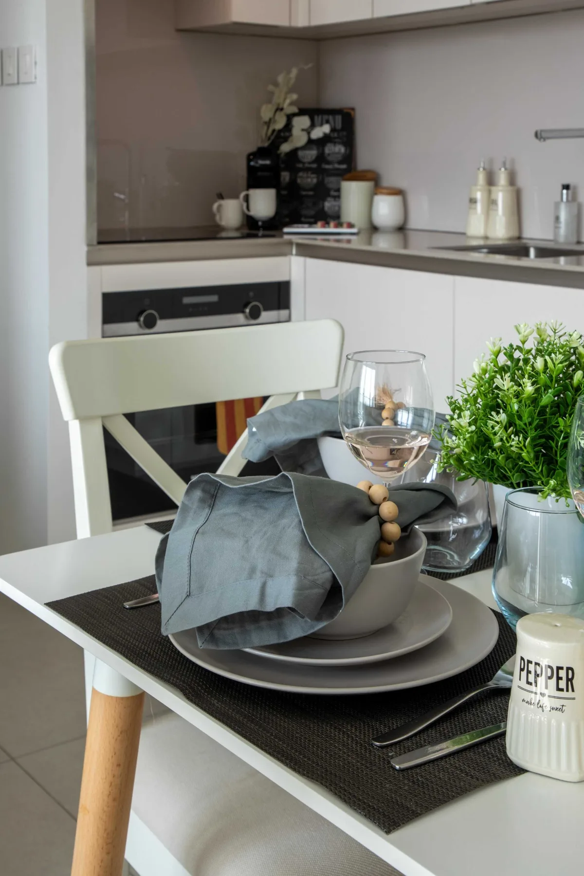 Una mesa preparada para comer está frente a una cocina compacta.
