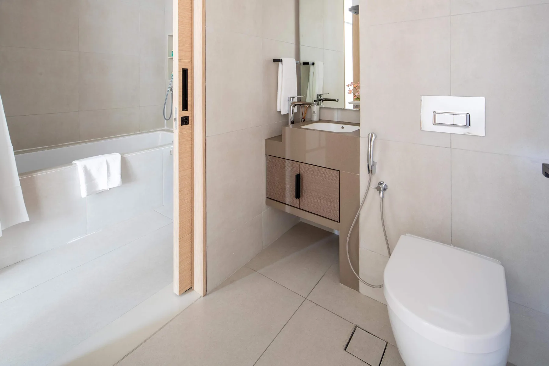 Un baño alicatado con bañera, lavabo con mueble e inodoro.