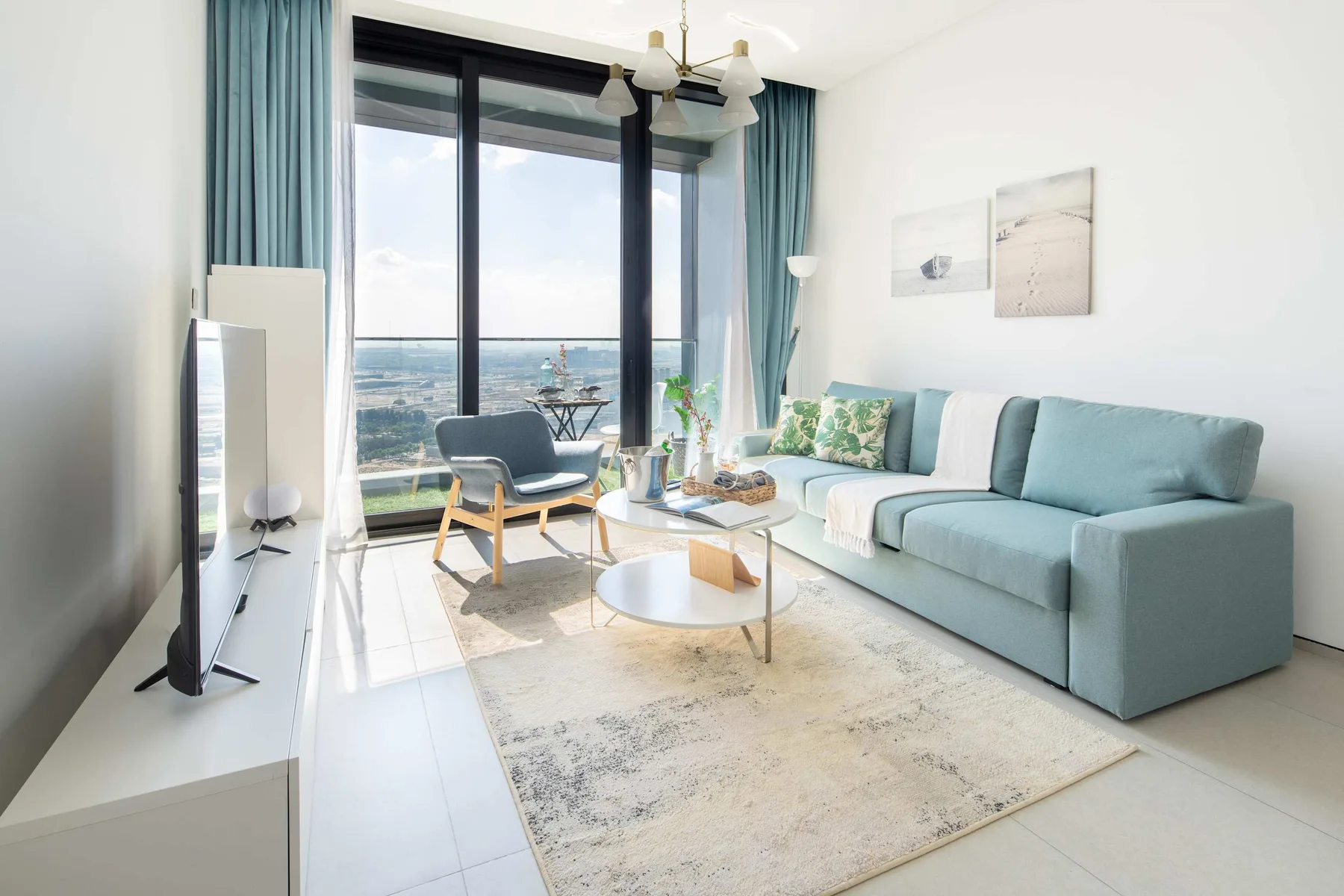 Una sala luminosa con asientos azules junto a grandes ventanas.