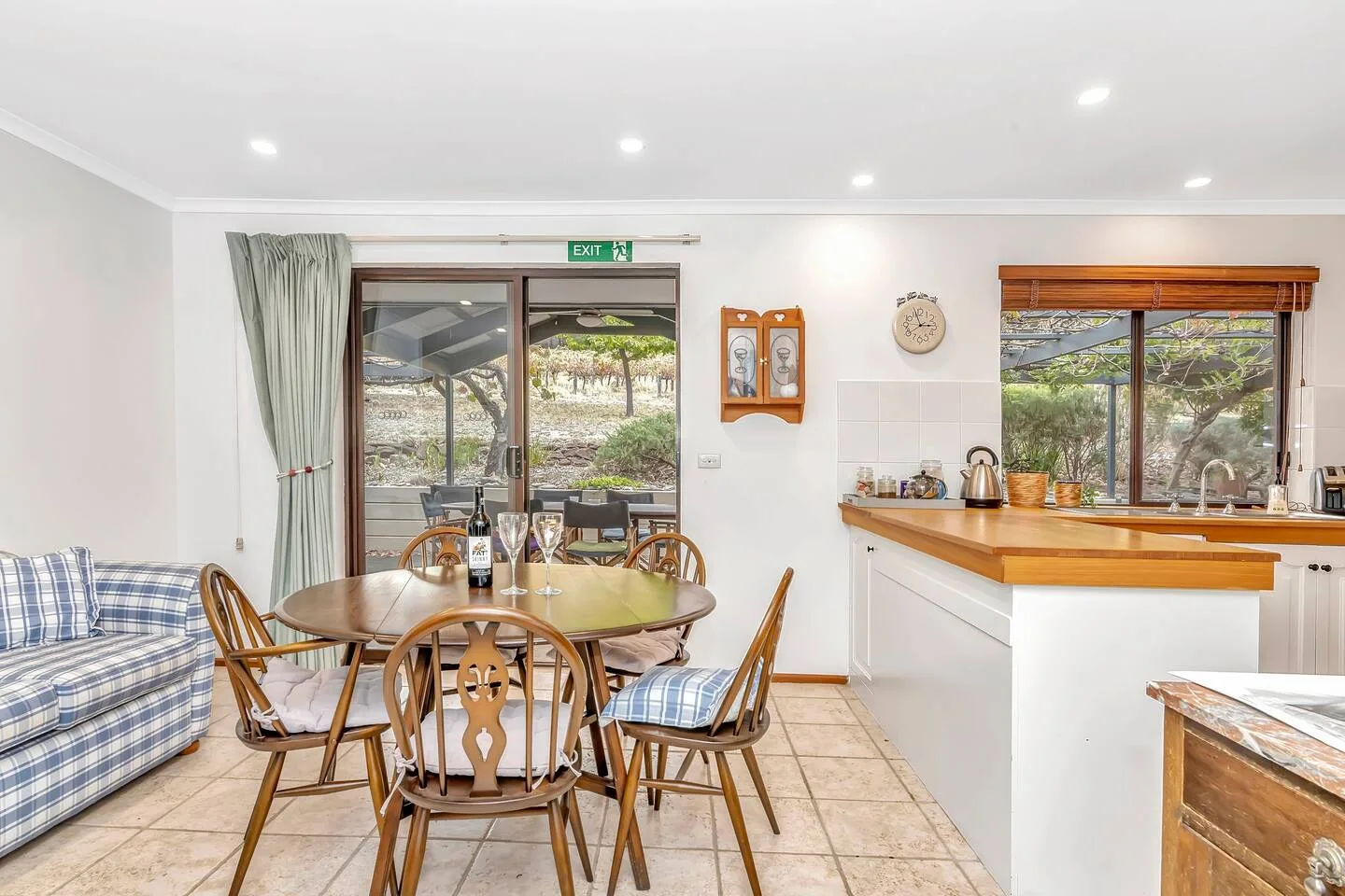 Comedor de planta abierta junto a una cocina, con puertas de vidrio que dan a un patio.
