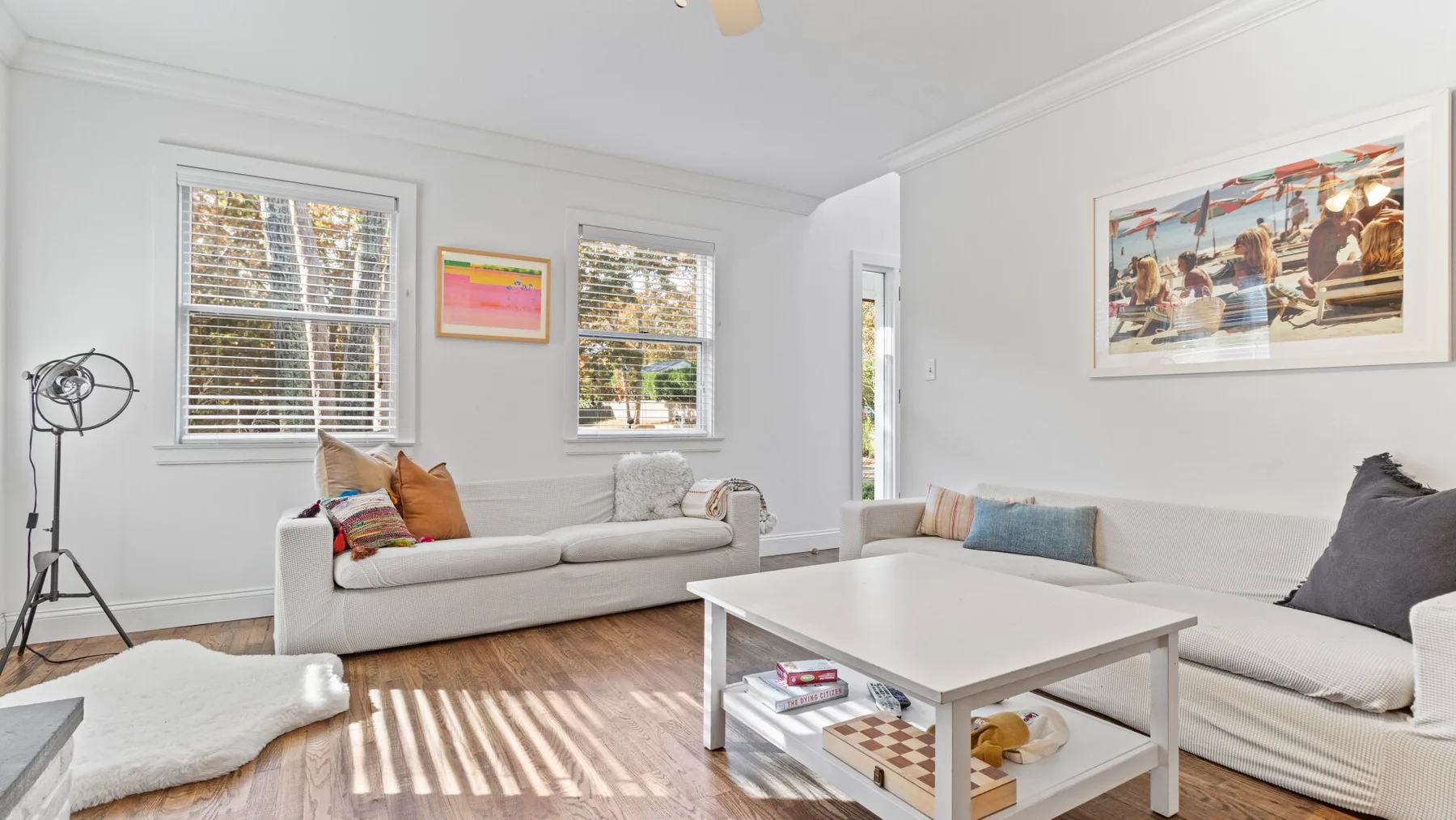 Una sala luminosa con asientos claros y una mesa de centro blanca.
