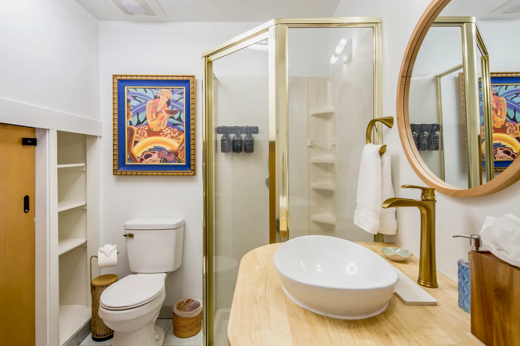 A bathroom with a glass shower, toilet, and sink vanity.