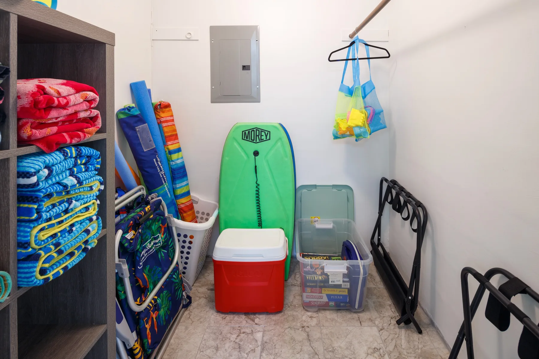 A storage area with folded towels, beach gear, and a cooler.