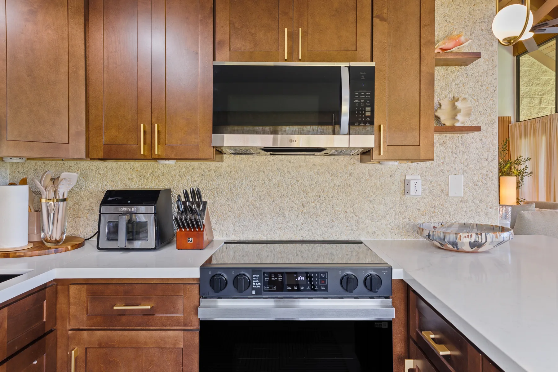 A kitchen with wooden cabinets, a microwave, and a stove.