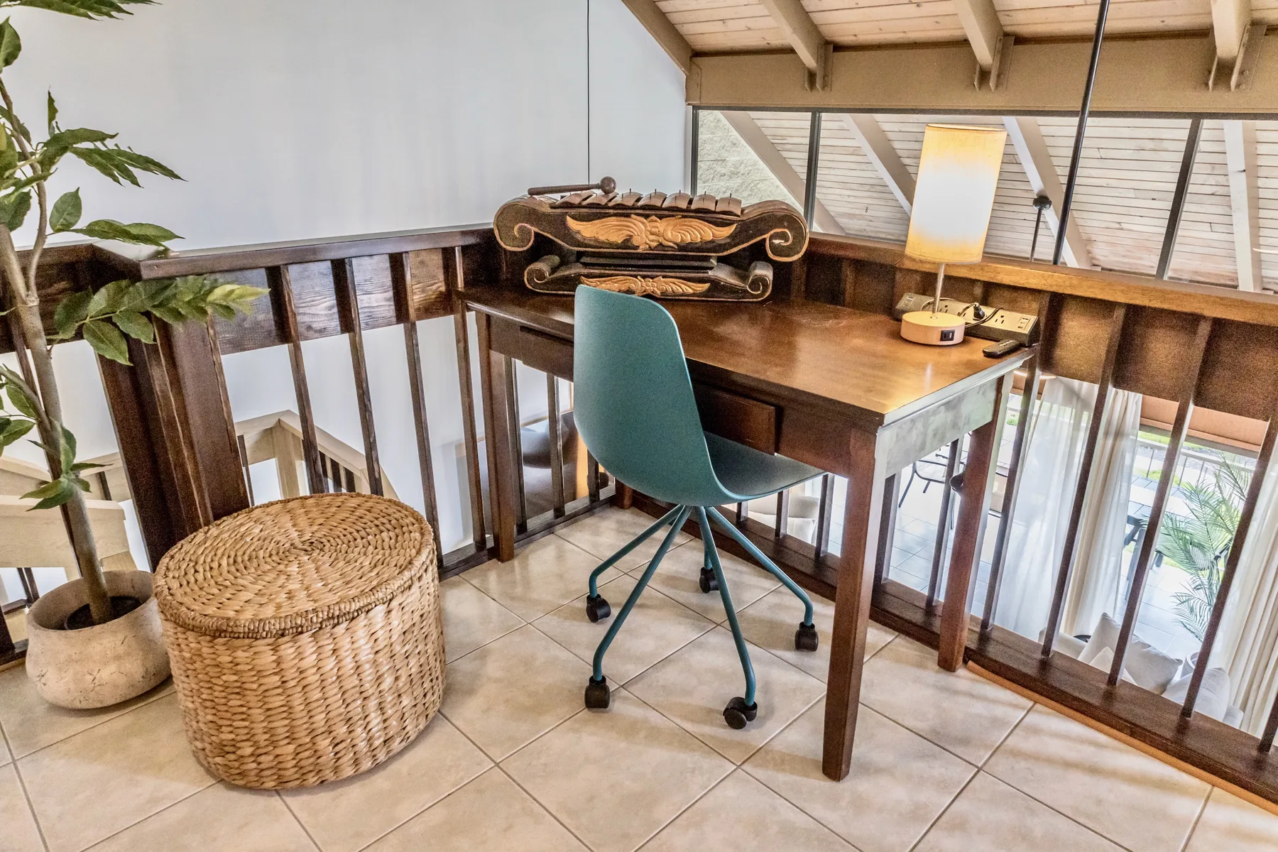 A desk and seating sit beside wooden railings in a bright loft workspace.