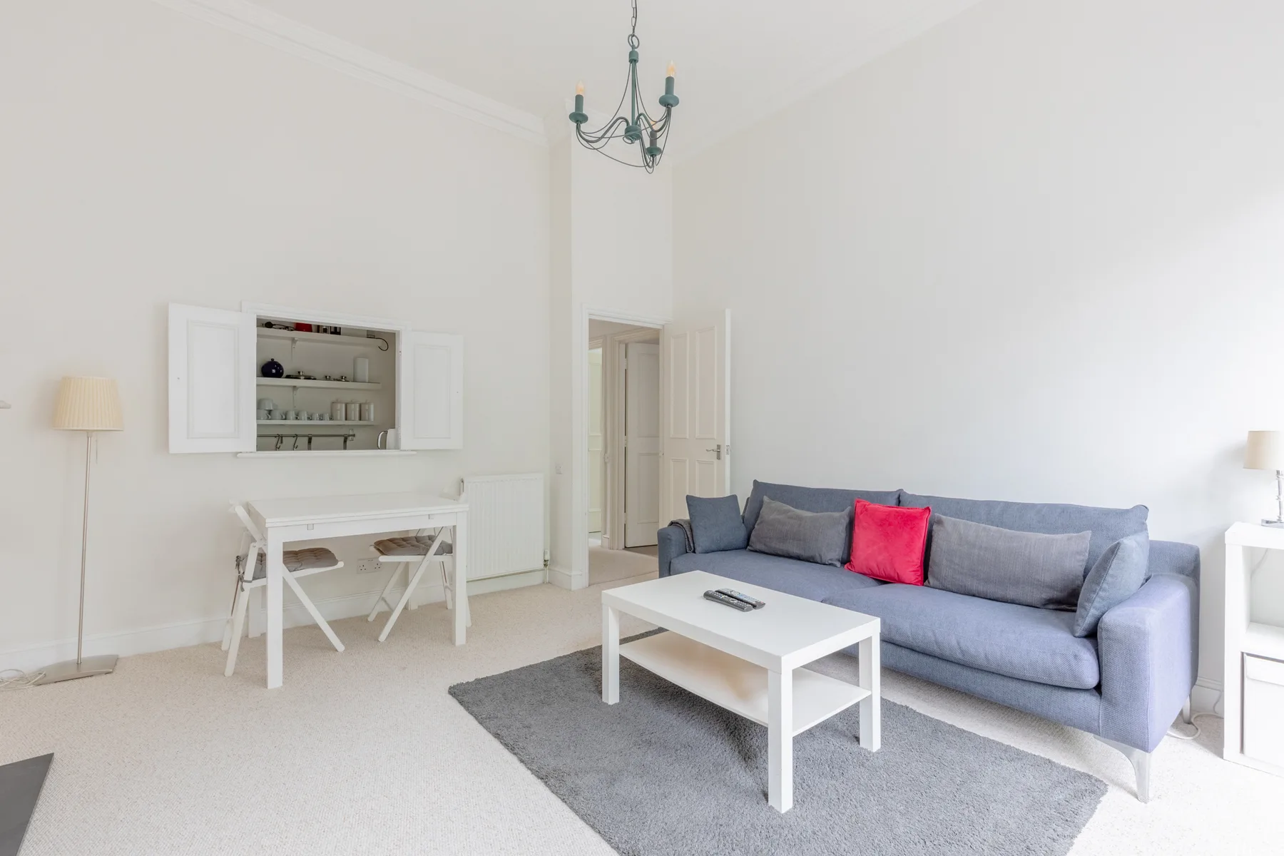 A bright living room with a gray sofa and white coffee table.