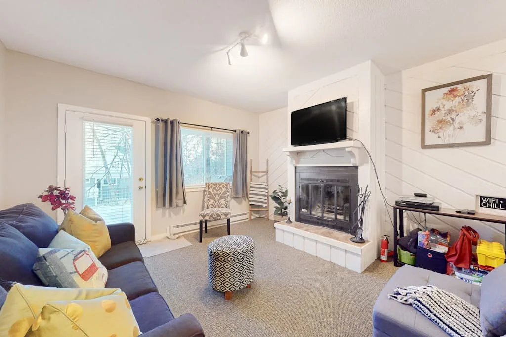 Living room with seating, a fireplace, and a television.