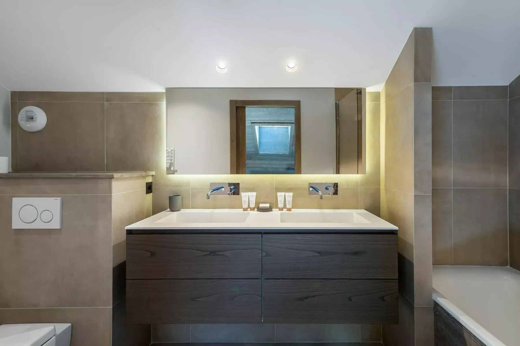 A modern bathroom with a double sink vanity and a bathtub.