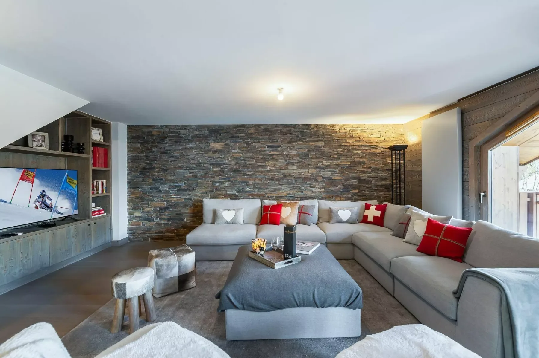 Una sala de estar con una amplia zona de asientos y un televisor.