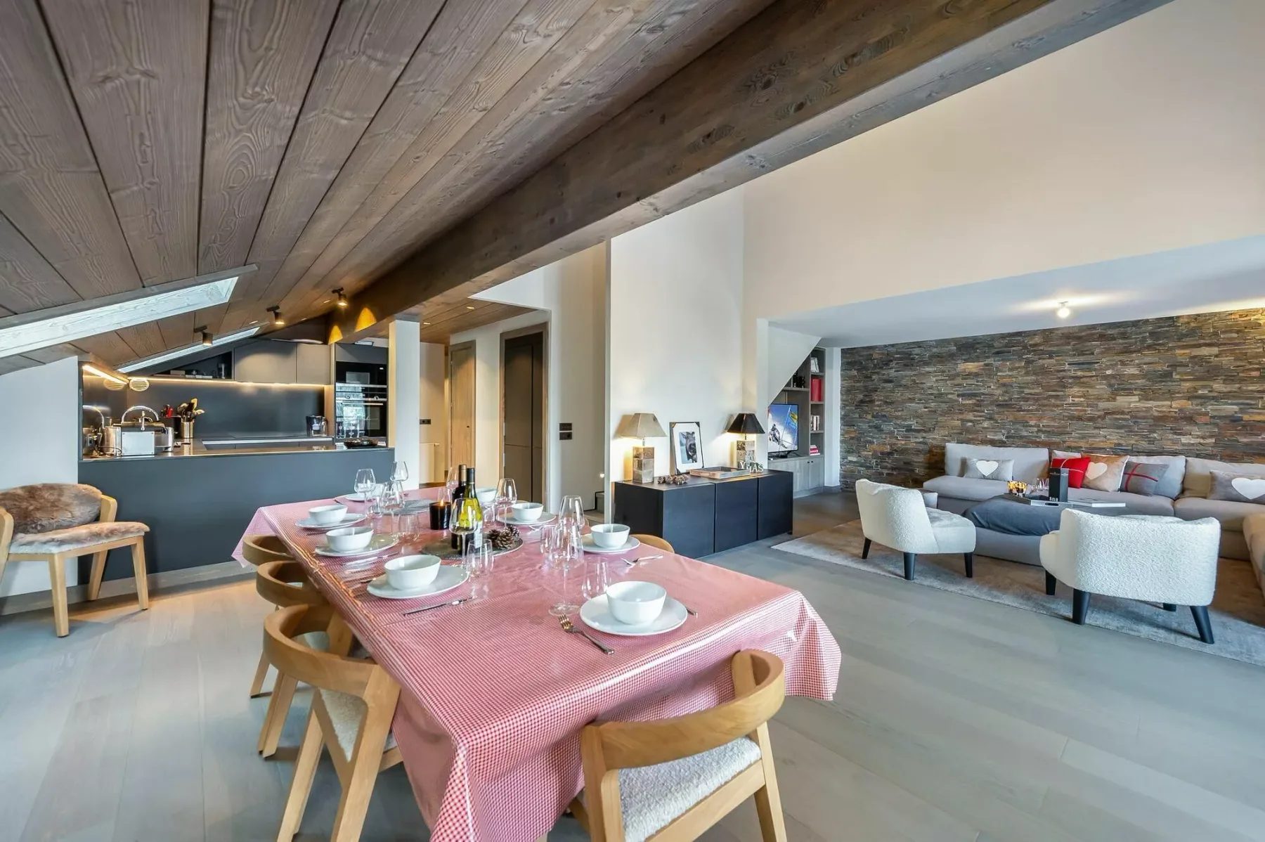 An open-plan dining area with a set table beside a living room.