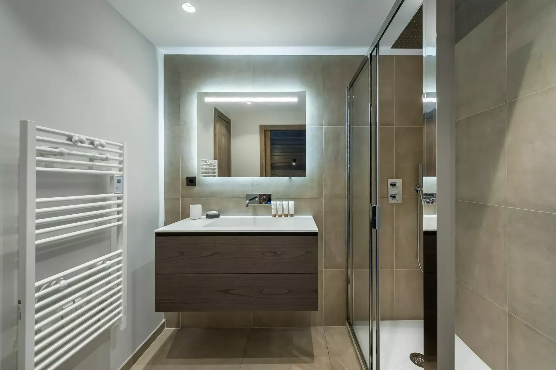 A modern bathroom with a floating vanity and glass shower.