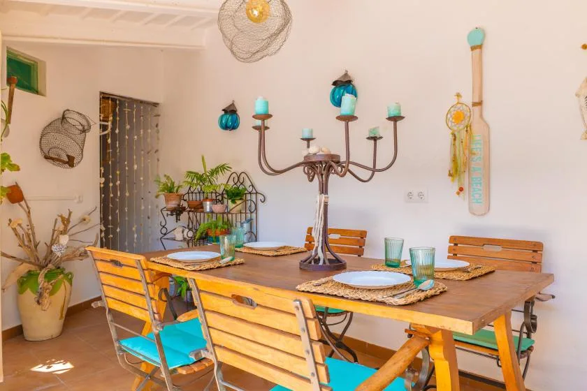 A dining area with a wooden table, chairs, and decorative plants.