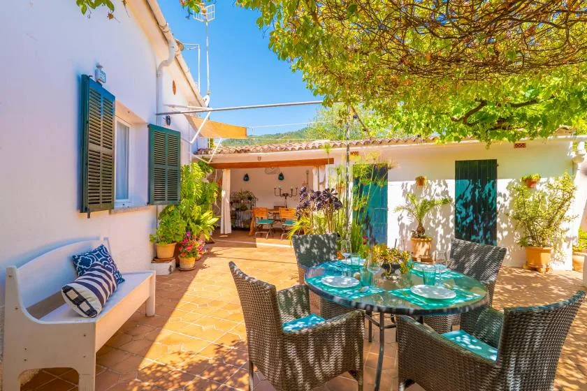 An outdoor courtyard dining area with a round table and surrounding seating.