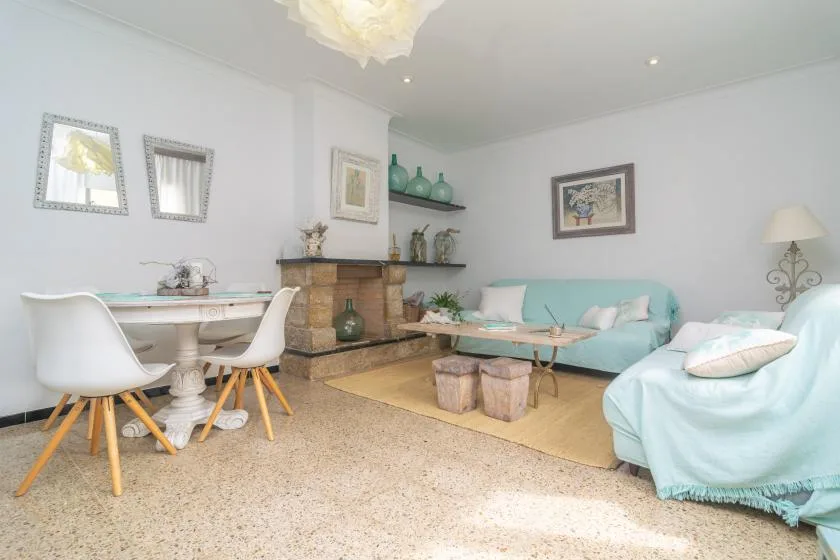 A bright living room with pale turquoise seating and a dining table.