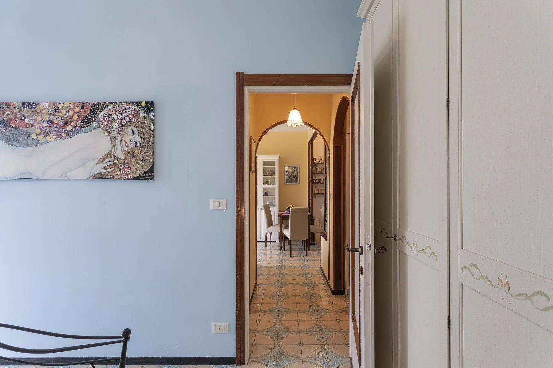Un pasillo se abre a un comedor a través de una puerta arqueada.