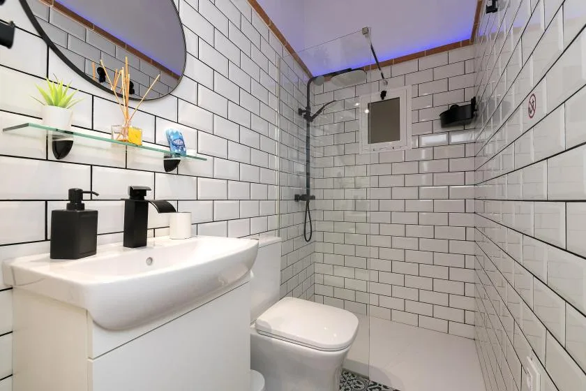 A tiled bathroom with a sink, toilet, and shower.