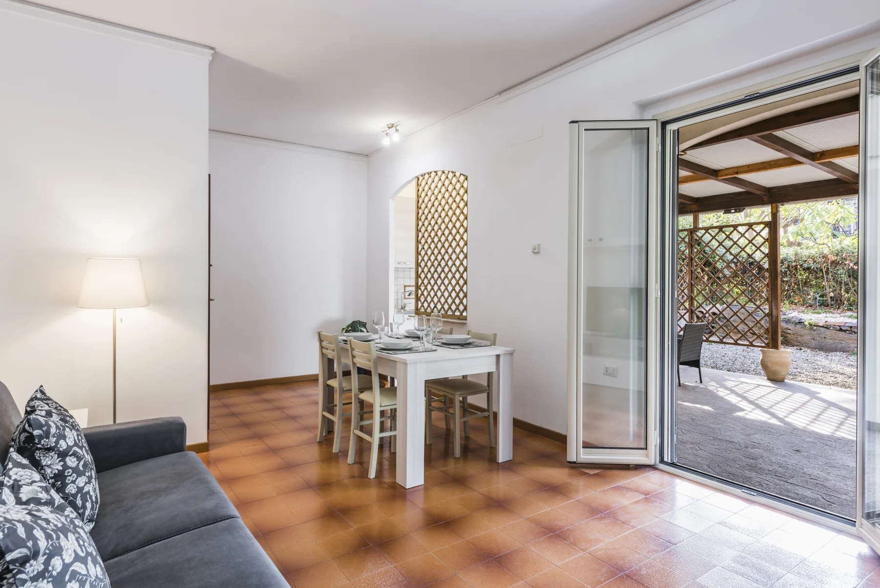 Un comedor luminoso se abre a un patio cubierto mediante puertas corredizas de vidrio.