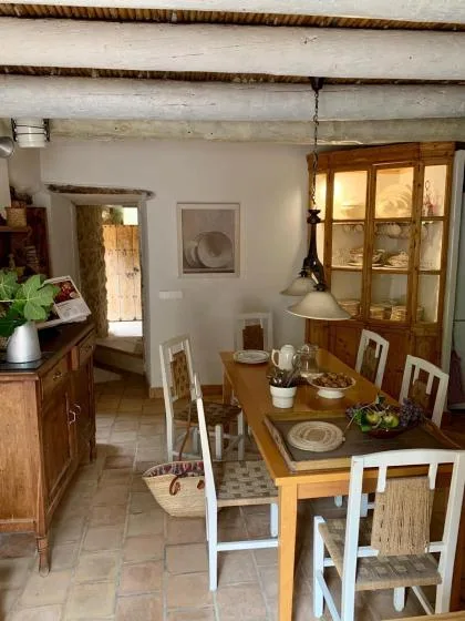 Un comedor con una mesa de madera y sillas bajo vigas expuestas.