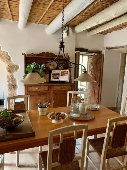 Un comedor rústico con una mesa de madera con platos bajo lámparas colgantes.