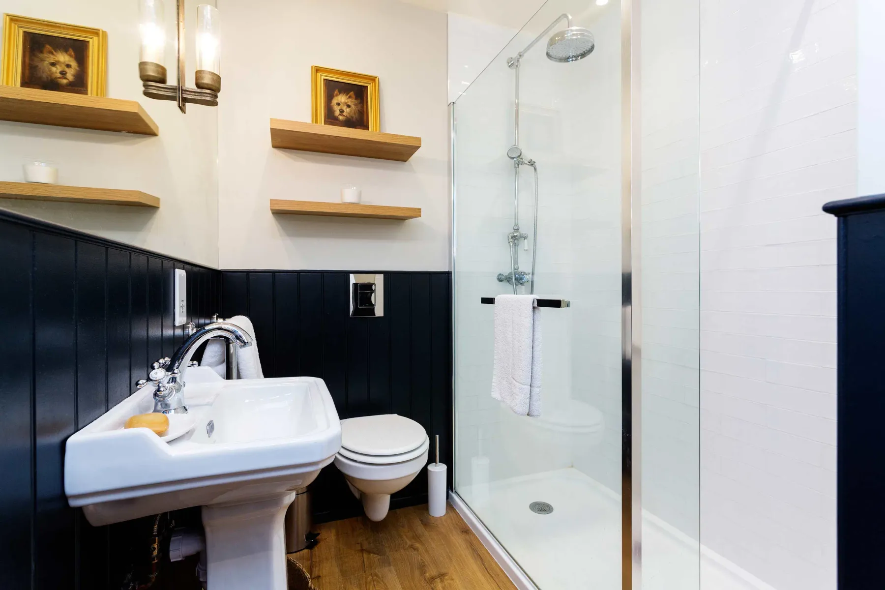 Un baño con lavabo de pedestal y ducha de vidrio.
