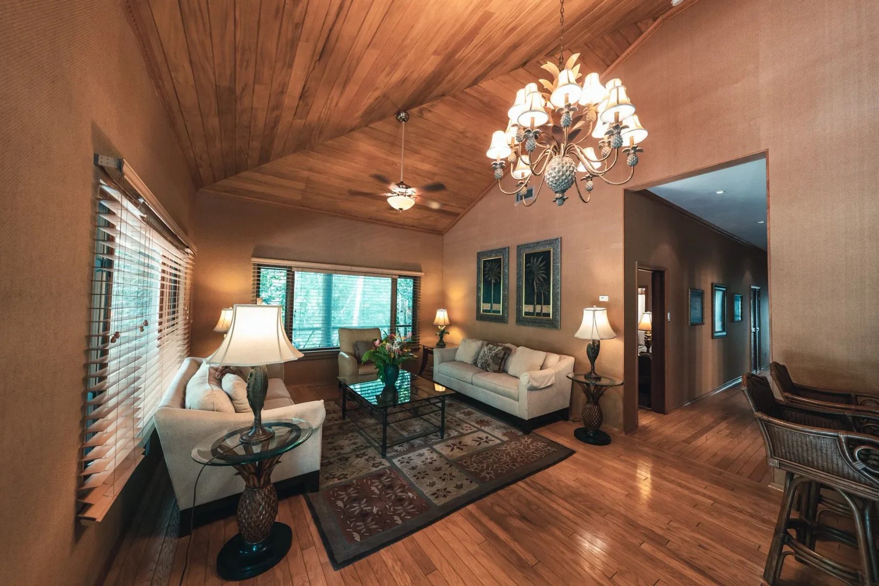 Sala de estar con techo abovedado revestido de madera, sofás y ventilador de techo