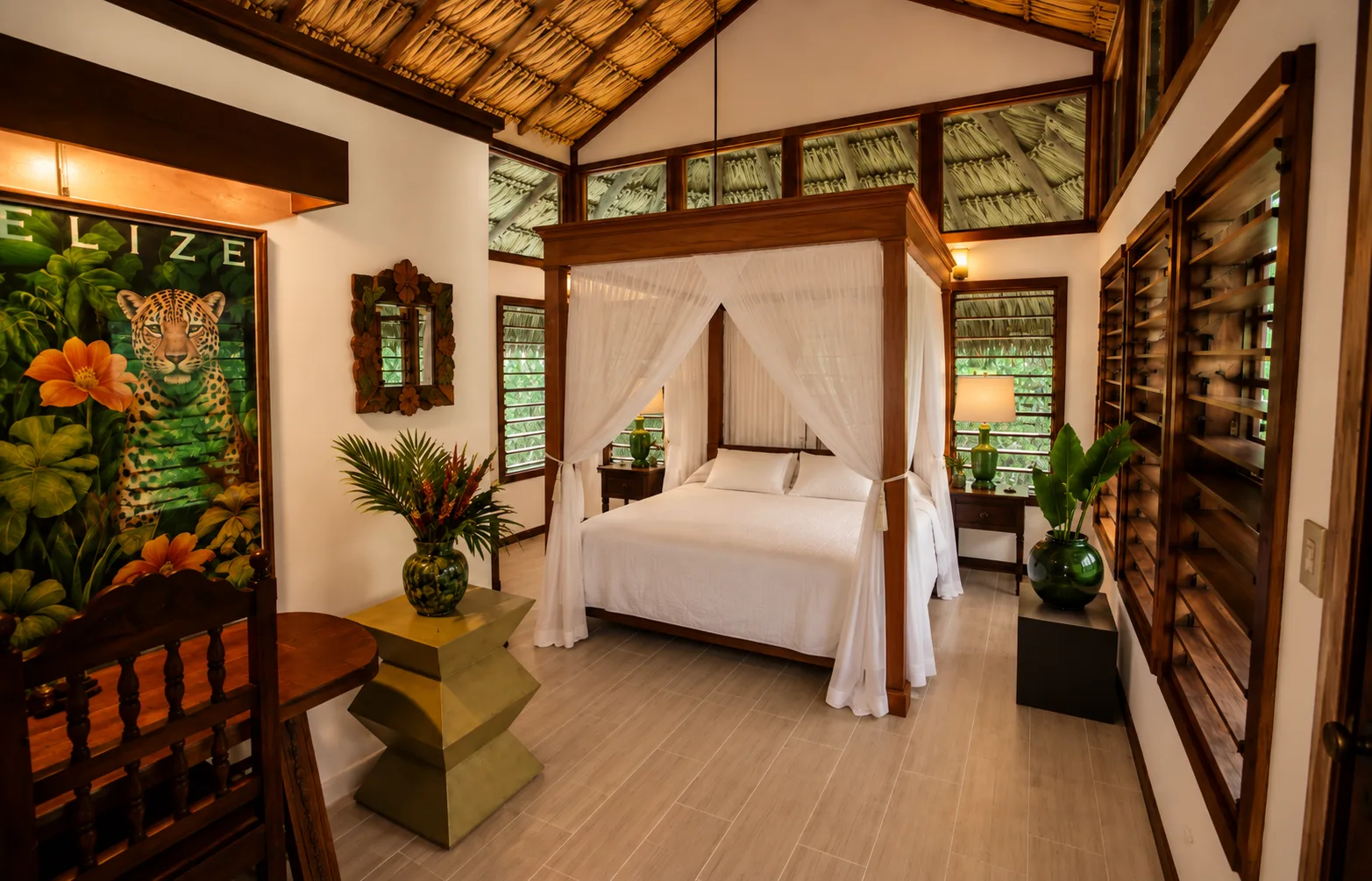 Dormitorio de estilo tropical con cama con dosel, muebles de madera y vegetación en el exterior