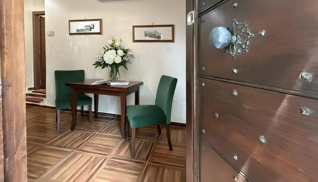 Vista de una habitación amueblada a través de una puerta de madera abierta.