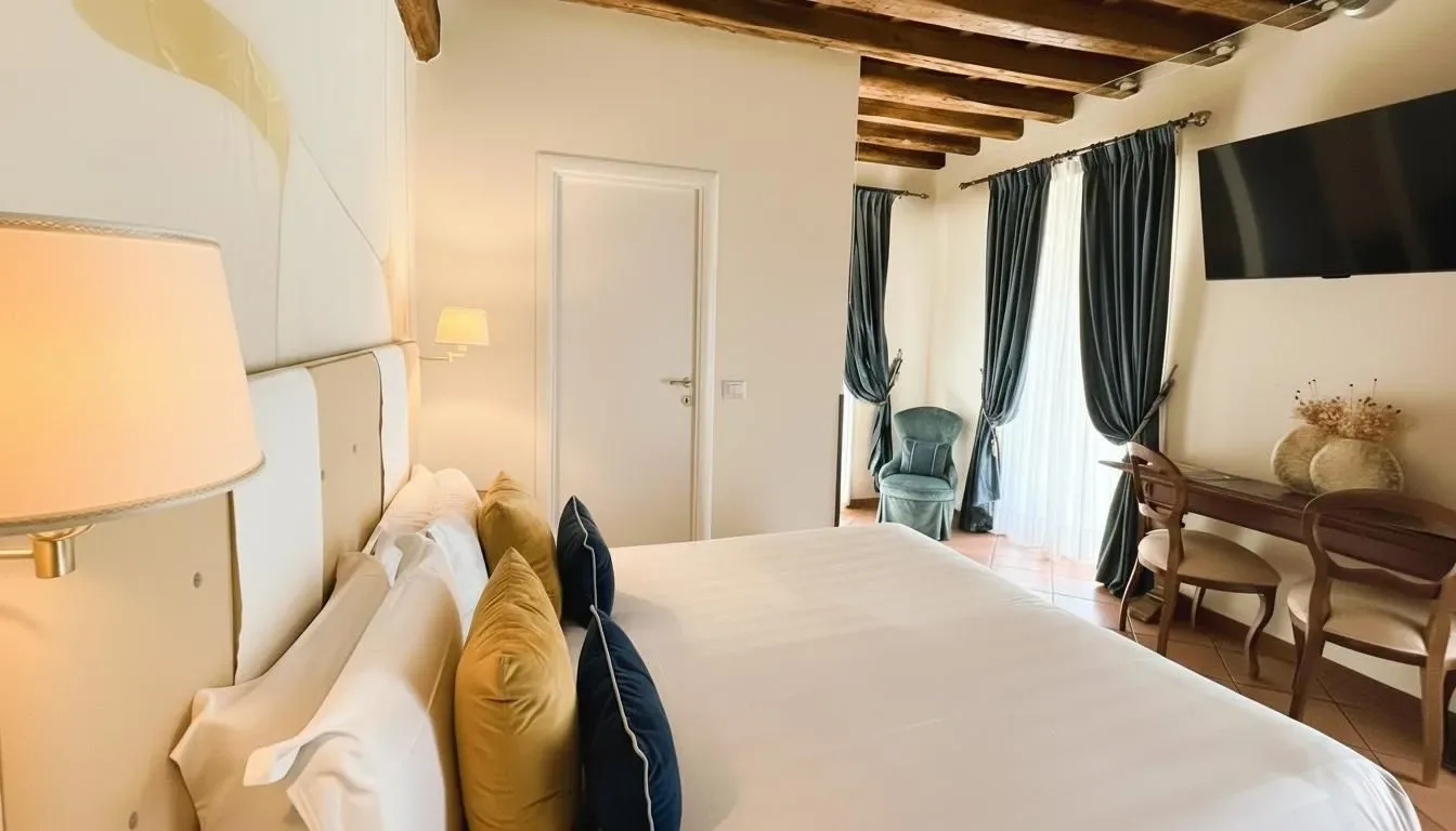 Dormitorio con cama, vigas de madera, cortinas y escritorio.