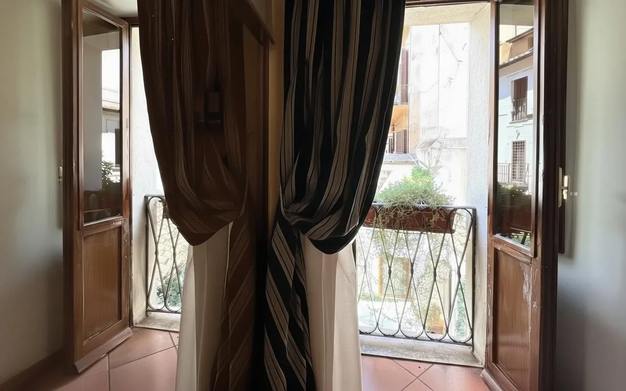 Puertas abiertas que dan a un balcón con barandilla metálica.